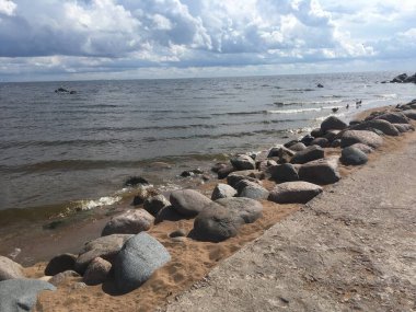 Büyük taşları ve kumları olan nehir kıyısı. Finlandiya Körfezi.
