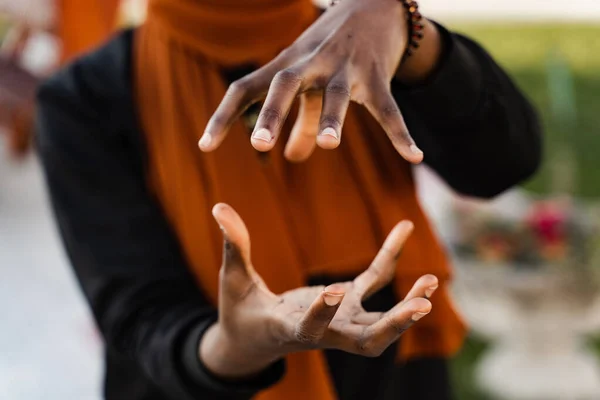 Close-up hands of black muslim woman at qigong chinese meditation and sport training outdoor. African girl is meditating outdoor near chinese arbor