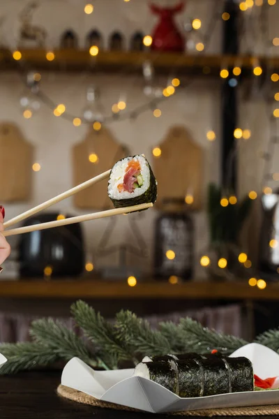Manteniendo Rollo Sushi Fondo Las Luces Del Año Nuevo Decoración — Foto de Stock
