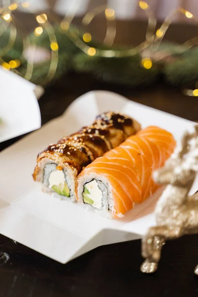 Sushi Toczą Się Tle Noworocznych Świateł Świąteczne Lampki Dekoracyjne Dostawa — Zdjęcie stockowe