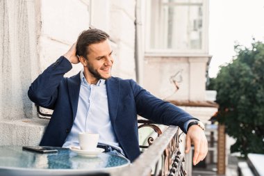 Kafede bir fincan kahveyle yakışıklı bir adam. Erkeklerin sabah yaşam tarzı