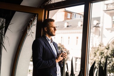 İş adamı, kafede bir fincan kahveyle takım elbise giydi. Sakallı adam yaşam tarzı