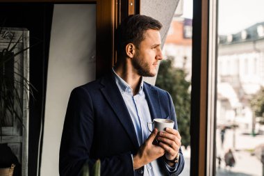 İş adamı, kafede bir fincan kahveyle takım elbise giydi. Sakallı adam yaşam tarzı