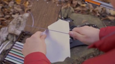 Profesyonel bıçak bileyicisi ve bileyici taşların yanında keskin bir bıçakla kağıt kesme işlemi. 4k video.
