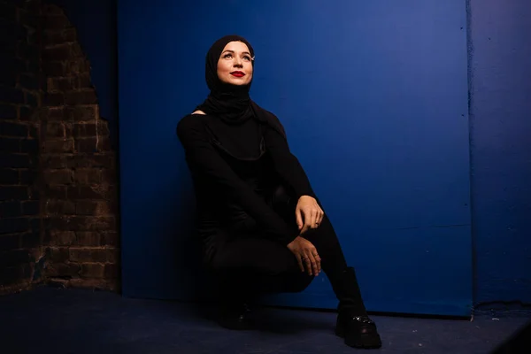 穿着黑色头巾的时尚穆斯林模特正出现在工作室的蓝色背景上 伊斯兰教 — 图库照片