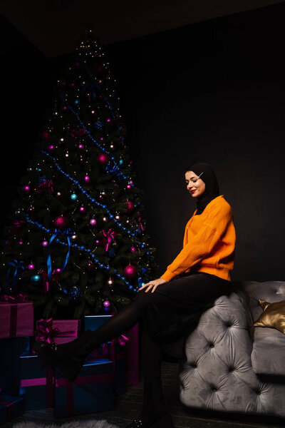 Muslim woman in black hijab near new year tree waiting for celebration of Christmas. Islam religion — Stock Image Muslim Woman Black Hijab New Year Tree Waiting Celebration Christmas Stock Photo