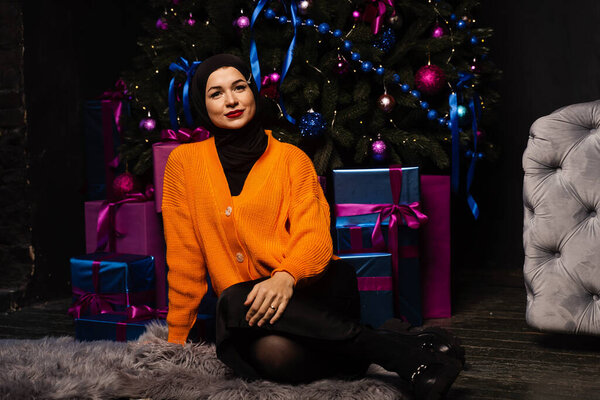 Muslim girl in black hijab is dreaming about gift at new year holiday. Christmas celebration of islamic religion people — Stock Image Muslim Girl Black Hijab Dreaming Gift New Year Holiday Christmas Stock Picture