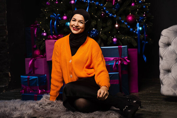 Muslim girl in black hijab is dreaming about gift at new year holiday. Christmas celebration of islamic religion people — Stock Image Muslim Girl Black Hijab Dreaming Gift New Year Holiday Christmas Stock Picture