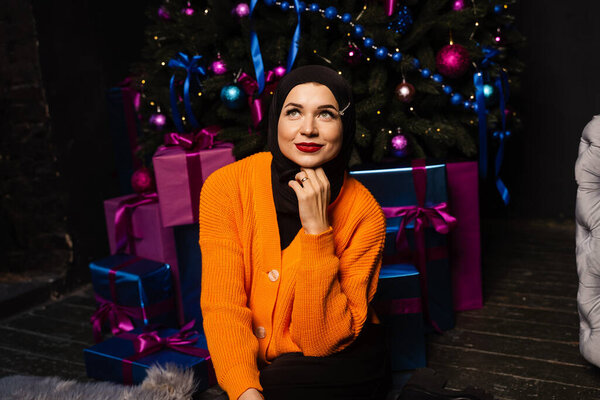 Muslim girl in black hijab is dreaming about gift at new year holiday. Christmas celebration of islamic religion people — Stock Image Muslim Girl Black Hijab Dreaming Gift New Year Holiday Christmas Royalty Free Stock Photos