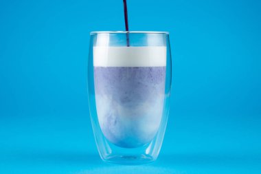 Çift cam bardakta mor goji eşleşmesi. Mavi arkaplanda kibrit kokteyli