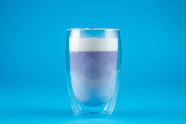 Mavi arka planda mor goji eşleşmesi. Çift cam bardakta kibrit kokteyli.