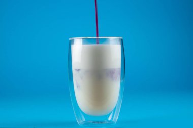 Çift cam bardakta mor goji eşleşmesi. Mavi arkaplanda kibrit kokteyli