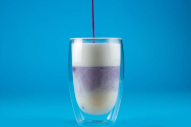 Çift cam bardakta mor goji eşleşmesi. Mavi arkaplanda kibrit kokteyli