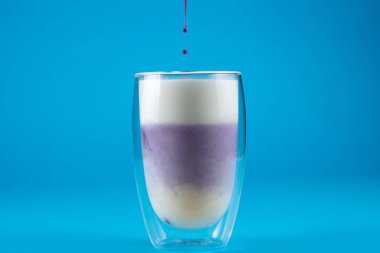 Çift cam bardakta mor goji eşleşmesi. Mavi arkaplanda kibrit kokteyli