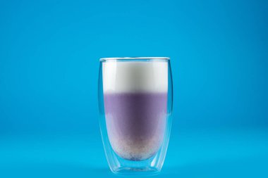 Mavi arka planda mor goji eşleşmesi. Çift cam bardakta kibrit kokteyli.