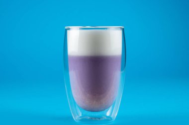 Mavi arka planda mor goji eşleşmesi. Çift cam bardakta kibrit kokteyli.