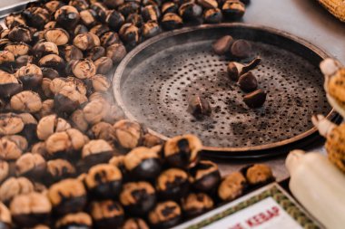 Tavada kestane kızartma işlemi. Sokak pazarında ızgara kestane çerezi..