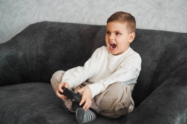 Etkileyici erkek oyuncu evde bir oyun alanıyla bilgisayar oyunu oynuyor. Çocukların kumarı.