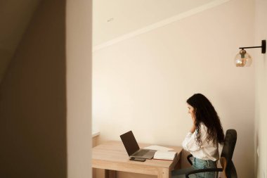 Laptop bilgisayarında iletişim kurmak için web kamerasını kullanan arkadaş canlısı video görüşmesinden hoşlanan bir kız. Memleketteki meslektaşlarımla video iletişimi