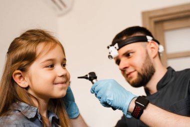 Ototoskoplu KBB doktoru. Otoskopi. Çocuk doktoru otolarolog otoskoptan çocuğun kulaklarına bakar. Otoskopi. Tedavi kulak ağrısı