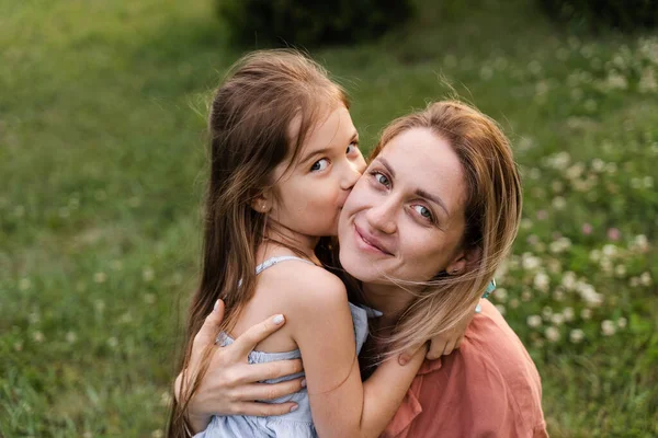 Daughter kissing and embrace her mom. Hapiness emotion. Family values. Happy family lifestyle. Happiness and joy of mom hugging her child