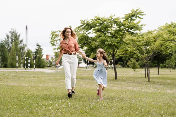 Mom and daughter run in the park and have fun. Family values and traditions. Happy childhood of a child. Mother plays with her daughter