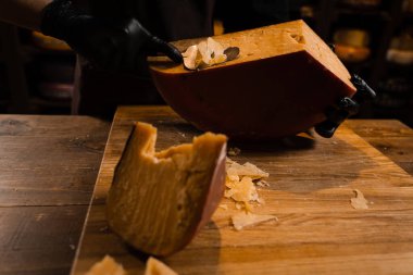 Peynirli sommelier dilimlenmiş peynirli gouda peyniri ve dilimleyici. Dükkanda peynir dilimliyorum. Atıştırmalık lezzetli bir parça peynir.