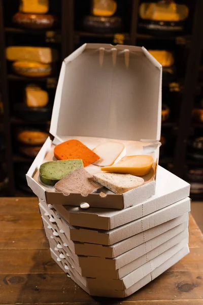 若いグダ 若いヤギ ラベンダーチーズ 緑と赤のペストチーズを段ボール箱に混ぜます チーズショップを宣伝するための創造的なアイデア — ストック写真
