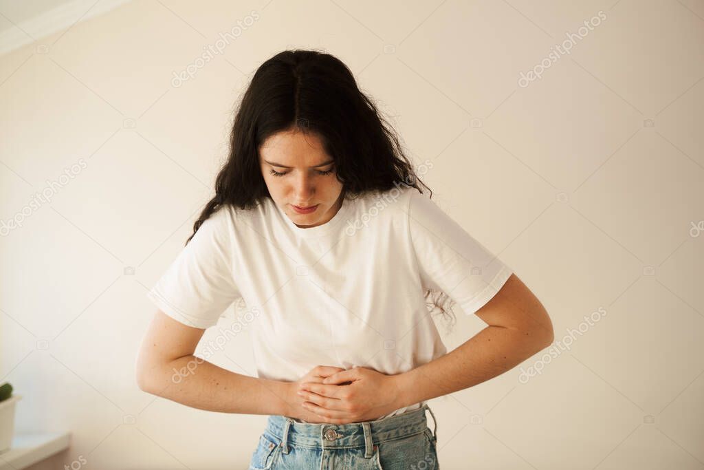 Stomach pain. Pancreatitis disease of pancreas becomes inflamed. Sick girl hold abdomen because it hurts