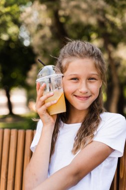 Açık havada limonata kokteyli. Portakallı limonata ve gülücükler taşıyan mutlu bir kız.