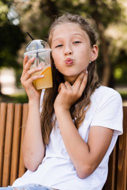 Açık havada limonata kokteyli. Portakallı limonata ve gülücükler taşıyan mutlu bir kız.