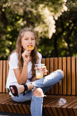 Açık havada limonata kokteyli. Portakallı limonata ve gülücükler taşıyan mutlu bir kız.