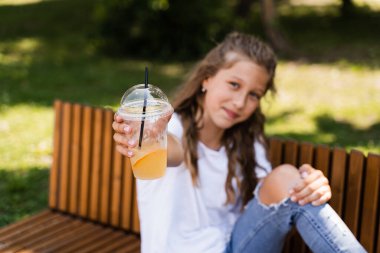 Açık havada limonata kokteyli. Portakallı limonata ve gülücükler taşıyan mutlu bir kız.