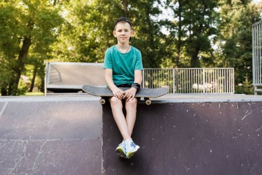 Kaykaylı çocuk. Kaykay tahtası olan genç bir çocuk kaykay parkında spor rampasında oturuyor. Olağanüstü bir yaşam tarzı. Kaykay ya da peni mağazaları ya da mağazalar için yaratıcı reklam