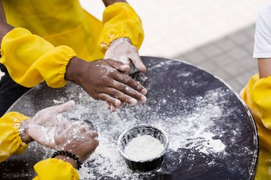 Çokuluslu çocukların elleri hamur için unla oynuyor ve yakın plan eğleniyor. Genç aşçı çocuklar khachapuri pişiriyor..