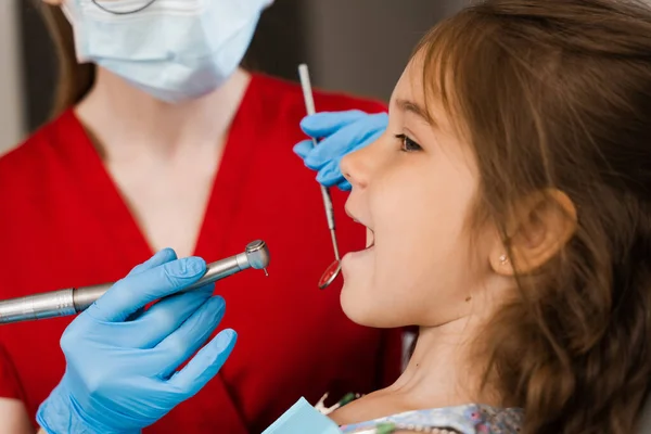 Dental drill close-up. Child dentist drilling teeth of kid girl in dentistry clinic. Teeth treatment. Dental filling for child patient