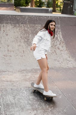 Skater child girl ride on skate board on skate park playground. Sports equipment for kids. Extreme sport lifestyle. Creative advert for skate or penny board shops or stores