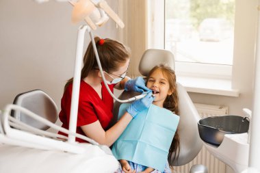 Pediatrik dişçi, dişçi çocuk hastalarını muayene eder ve muayene eder. Diş hekimliğindeki çocuk dişleri için profesyonel hijyen. Çocuk için profesyonel diş temizliği