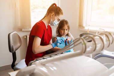 Diş hekimliğinde çocuk için ağız hijyenik çene anatomik modeli dersi. Dişçi çocuğa diş fırçasıyla dişlerini nasıl düzgün fırçalayacağını gösteriyor.