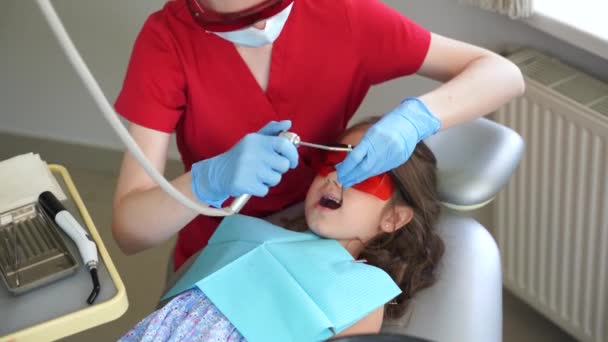 Dentysta Dziecięcy Leczy Usuwa Próchnicę Pacjenta Nagranie Oświetlenie Fotopolimerowej Procedury — Wideo stockowe