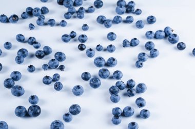 Blueberries with water drops on white background. Many blue berries on white table