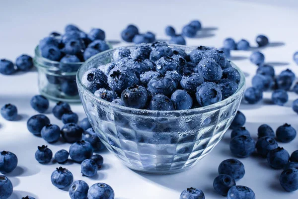 Blueberry with water drops. Blue berries in glass plate on white background. Many natural organic blueberries