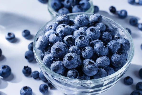 Blueberry with water drops. Blue berries in glass plate on white background. Many natural organic blueberries