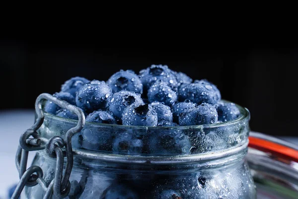 Blueberries Water Drops Close Glass Jar Black Background Blueberry Table — Zdjęcie stockowe
