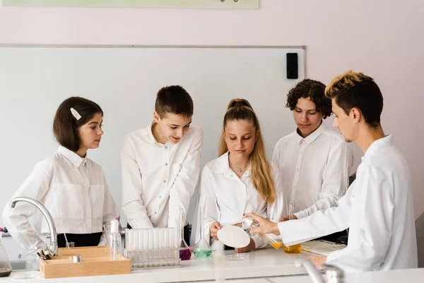 Education. Chemical experiments at a chemistry lesson at school. Children classmates making experiments in the laboratory