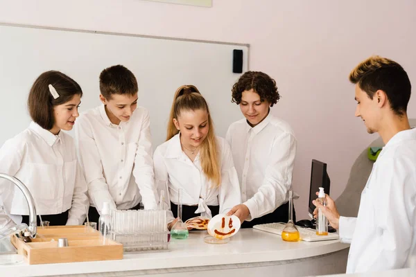 Education. Chemical experiments at a chemistry lesson at school. Children classmates making experiments in the laboratory