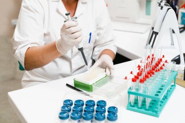 Kan analizi ve laboratuarda test için mikrodozer kullanılıyor. Laboratuvarda tıbbi malzemeler. Kan emici bilim adamı kan analizi yapıyor.