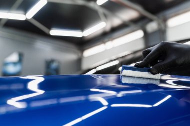 Arabayı çiziklerden korumak için nano seramik koruyucu palto kullanıyorum. Otomobil servisinin detaylandırılmasında sünger yakın çekim kullanılarak seramik katman uygulanması işlemi