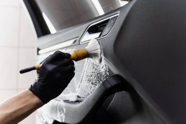 Araba kapısının içinde fırça kullanarak köpük ve deterjan yıkama. Araba temizleme servisi. Temizlik işçisi müşterilerin iç çamaşırlarını otomatik olarak yıkar
