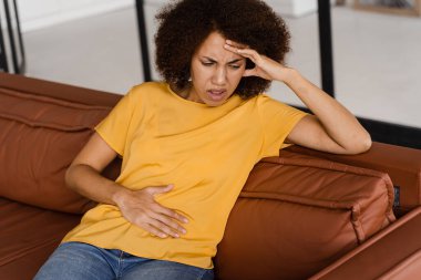 Mide ağrısı. Hasta Afro-Amerikalı kız karnını acıttığı için tutuyor. Pankreas iltihabı iltihaplanır.